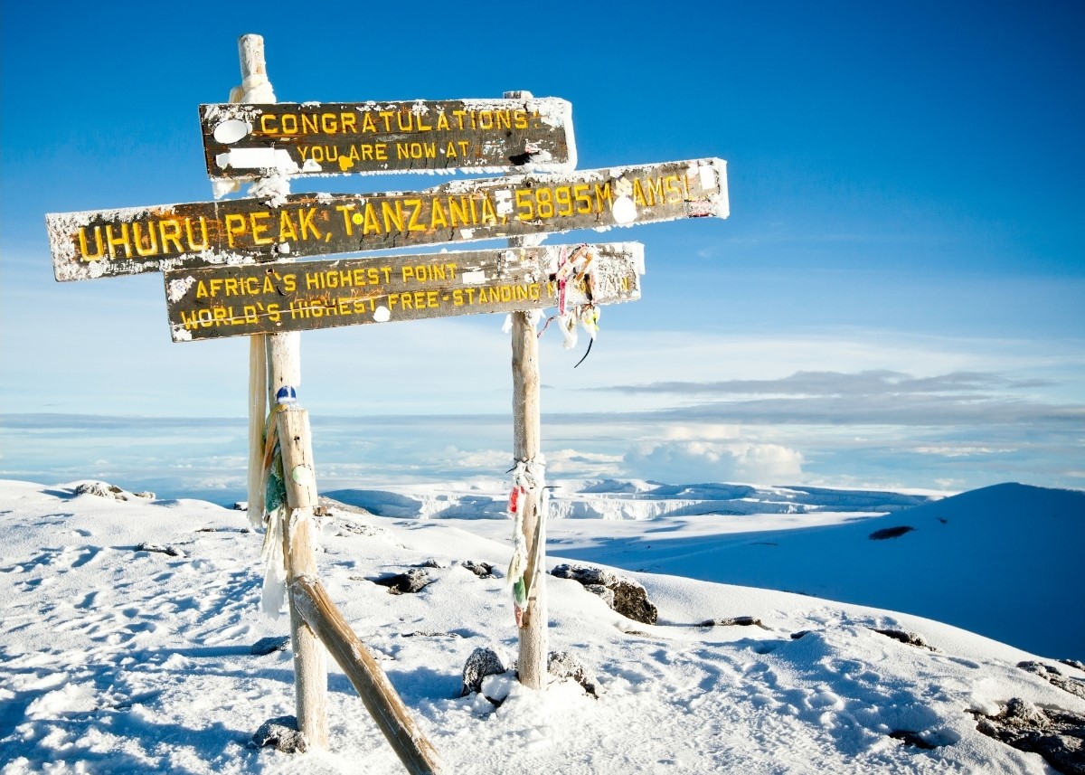 Trekkers walking toward the snow-capped summit of Mount Kilimanjaro